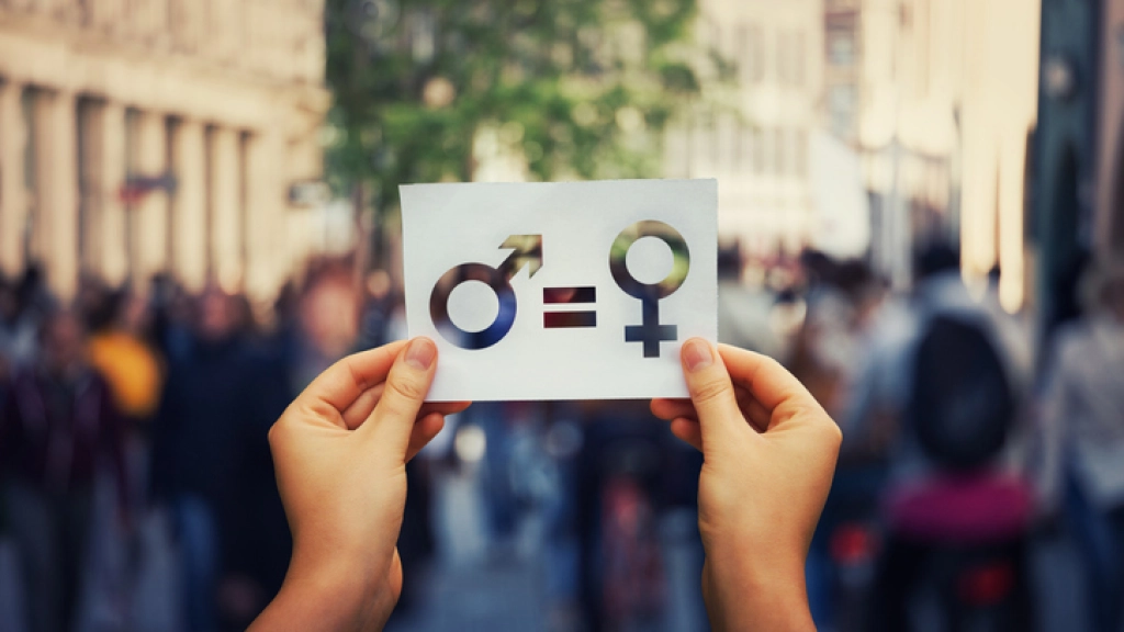 Sex sign as a metaphor of social issue, Gender equality concept as woman hands holding a white paper sheet with male and female symbol over a crowded city street background. Sex sign as a metaphor of social issue.