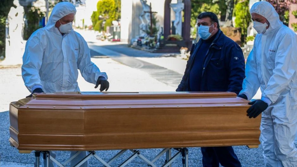ITALY-HEALTH-VIRUS-FUNERAL, Undertakers wearing a face mask and overalls unload a coffin out of a hearse on March 16, 2020 at the Monumental cemetery of Bergamo, Lombardy, as burials of people who died of the new coronavirus are being conducted at the rythm of one every half hour. (