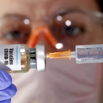 FILE PHOTO: A woman holds a small bottle labeled with a Vaccine COVID-19 sticker and a medical syringe in this illustration, Imagen de contexto. Créditos: REUTERS.