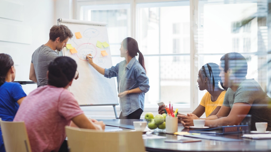 Business executives discussing with their colleagues on whiteboard, 