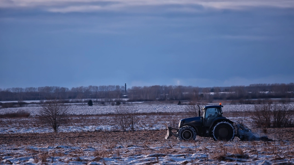 tractor-in-the-field-arable-land-winter-agribusiness-landscape-seasonal-work-in-snowy-field, Algunos cultivos, como el raps, son levantados del suelo por la escarcha, lo que separa su raíz del subsuelo y “sofoca” a la planta, causando su muerte.