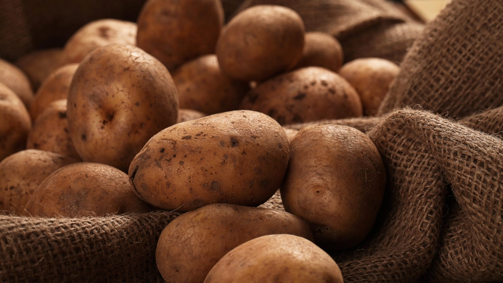 Rustic unpeeled potatoes on a desks, Los agricultores que no cuenten con una alta eficiencia tendrán dificultades para ser rentables. A pesar de esto, los costos para el consumidor se han mantenido similares a temporadas anteriores.