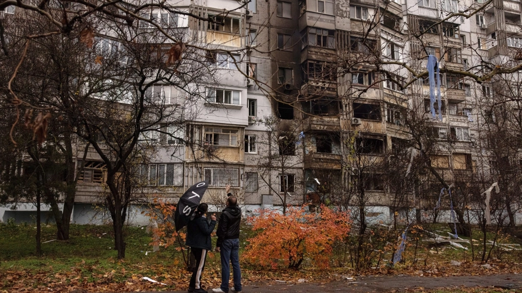 La guerra cumple nueve meses con Ucrania a oscuras, Ucranianos delante de un edificio dañado por bombas rusas en Jersón. EFE/EPA/ROMAN PILIPEY
