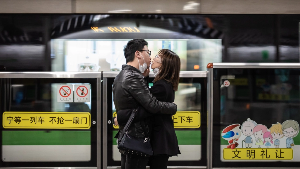 Shanghái recomienda no salir de casa en Navidad para evitar contagio de covid, Imagen de archivo de una pareja dándose un beso tras quitare la máscara para protegerse de covid en una estación de Shangai. EFE/ Liu Xingzhe