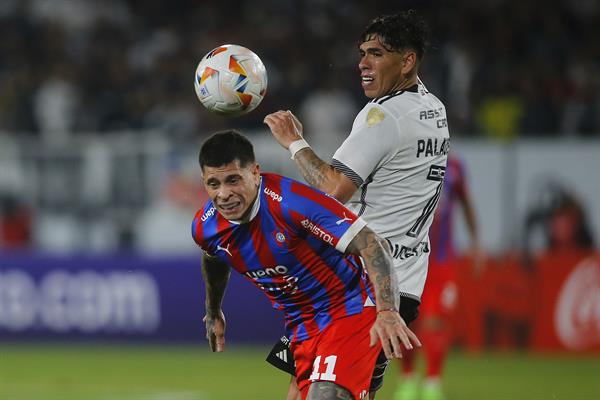 Carlos Palacios de Colo Colo disputa el balón con Juan Iturbe de Cerro en un partido de la fase de grupos de la Copa Libertadores. EFE/ Esteban Garay / EFE