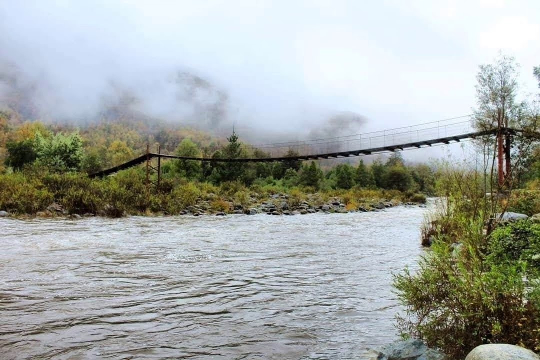 Así lucía la pasarela de Santa Lucía Bajo antes de su colapso durante el desborde del río Cholguán en el invierno de 2023. / Cedida