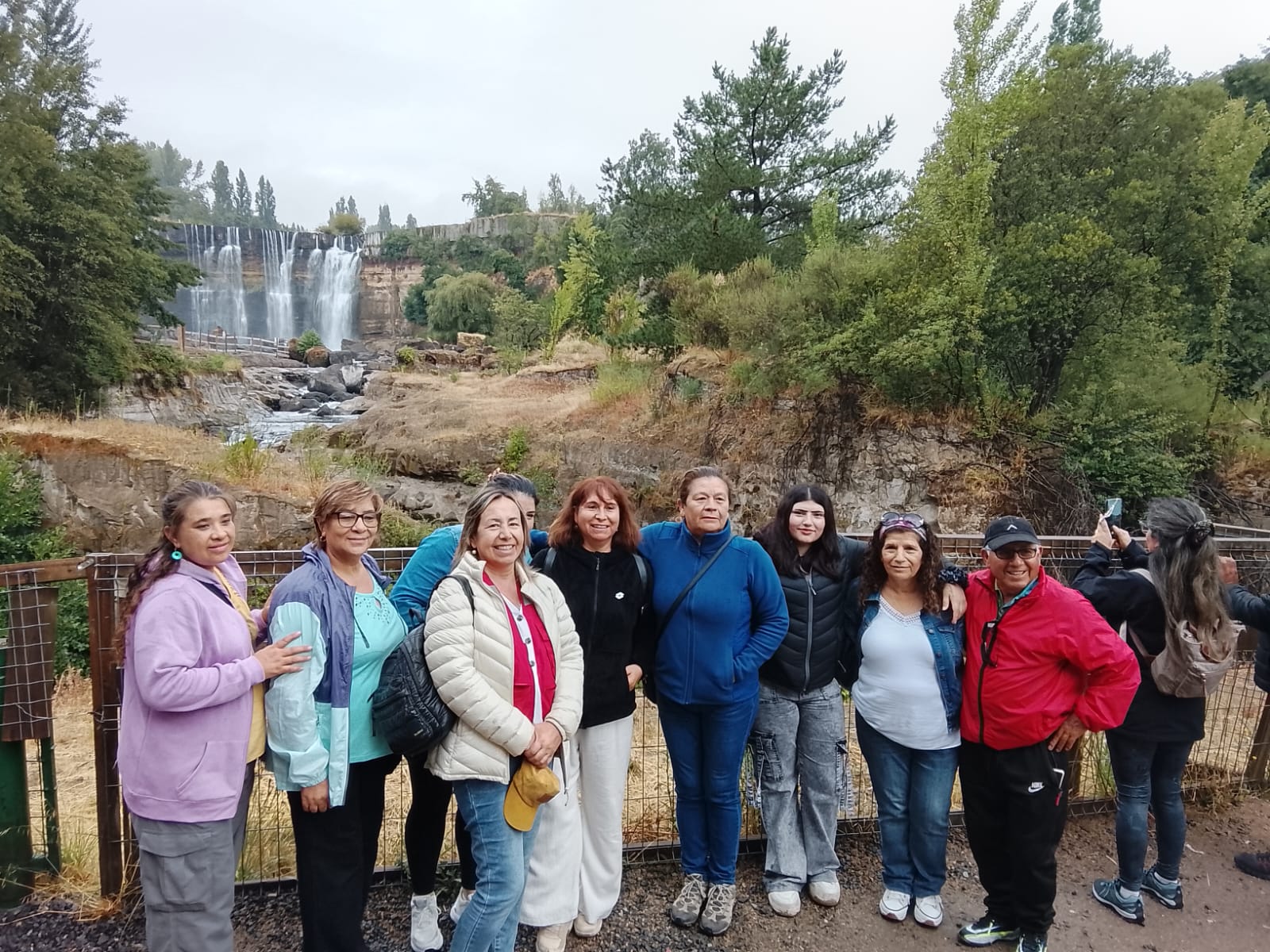 Parte del grupo proveniente de Requínoa posa en el sendero del sector, con las cascadas de los Saltos del Laja como fondo, durante la visita realizada este viernes. / Cedida
