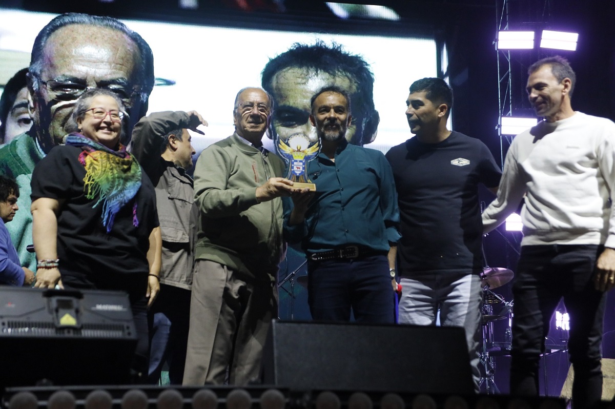 El alcalde José Pérez Arriagada entrega un reconocimiento a Los Bunkers durante su presentación en el Estadio Municipal. / Municipalidad de Los Ángeles