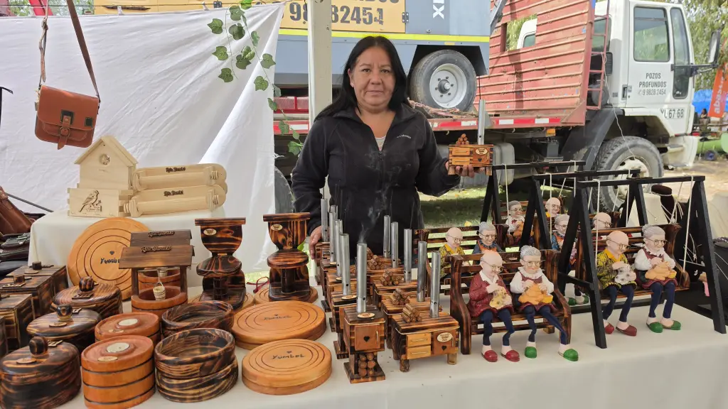 Alejandra González junto a las rústicas creaciones en madera de su emprendimiento Las brujitas, piezas funcionales y elaboradas a mano que comercializa habitualmente en la plaza de Yumbel., Diario La Tribuna