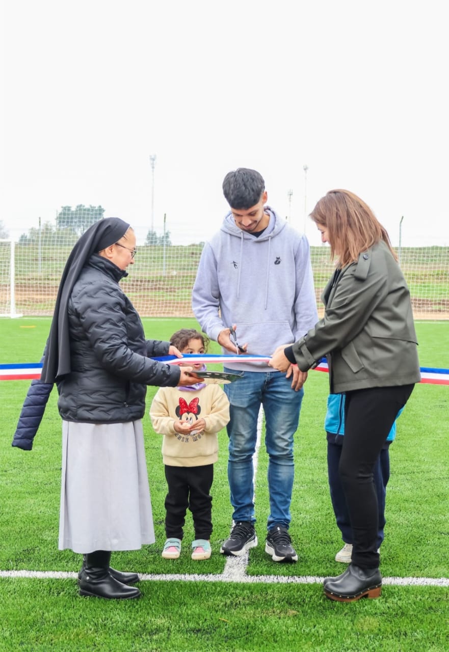 Jimy Martínez, jugador profesional de Universidad Católica, junto a la directora María Eliana Fuentes y la hermana María Goretti, participaron en el corte simbólico de cinta que marcó la inauguración de la nueva cancha sintética del Liceo Santa Cruz de Laja / La Tribuna